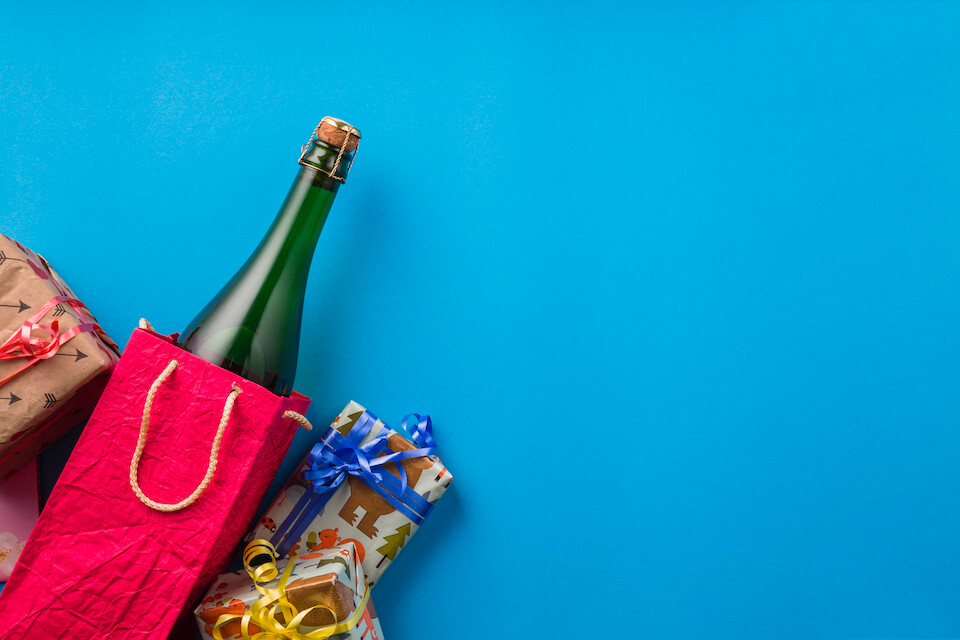 Presentes com bebidas e outros pacotes fechados em frente a um fundo azul