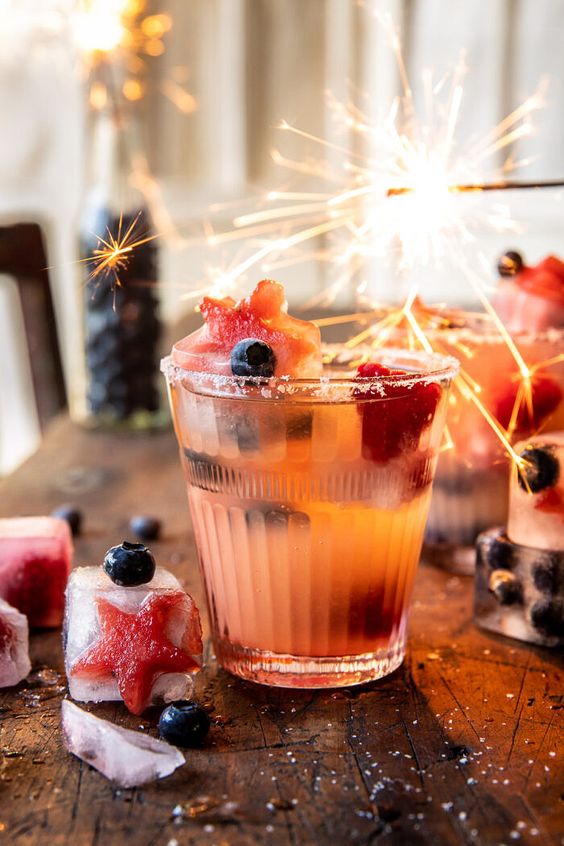 Drink de frutas vermelhas em cima de uma mesa e uma vela de aniversario