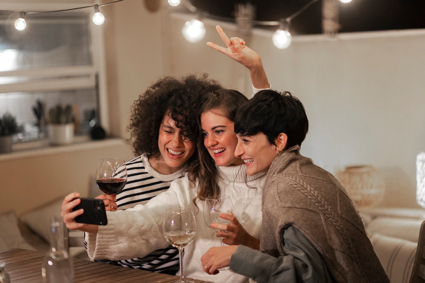 Amigas tirando uma foto e bebendo um vinho