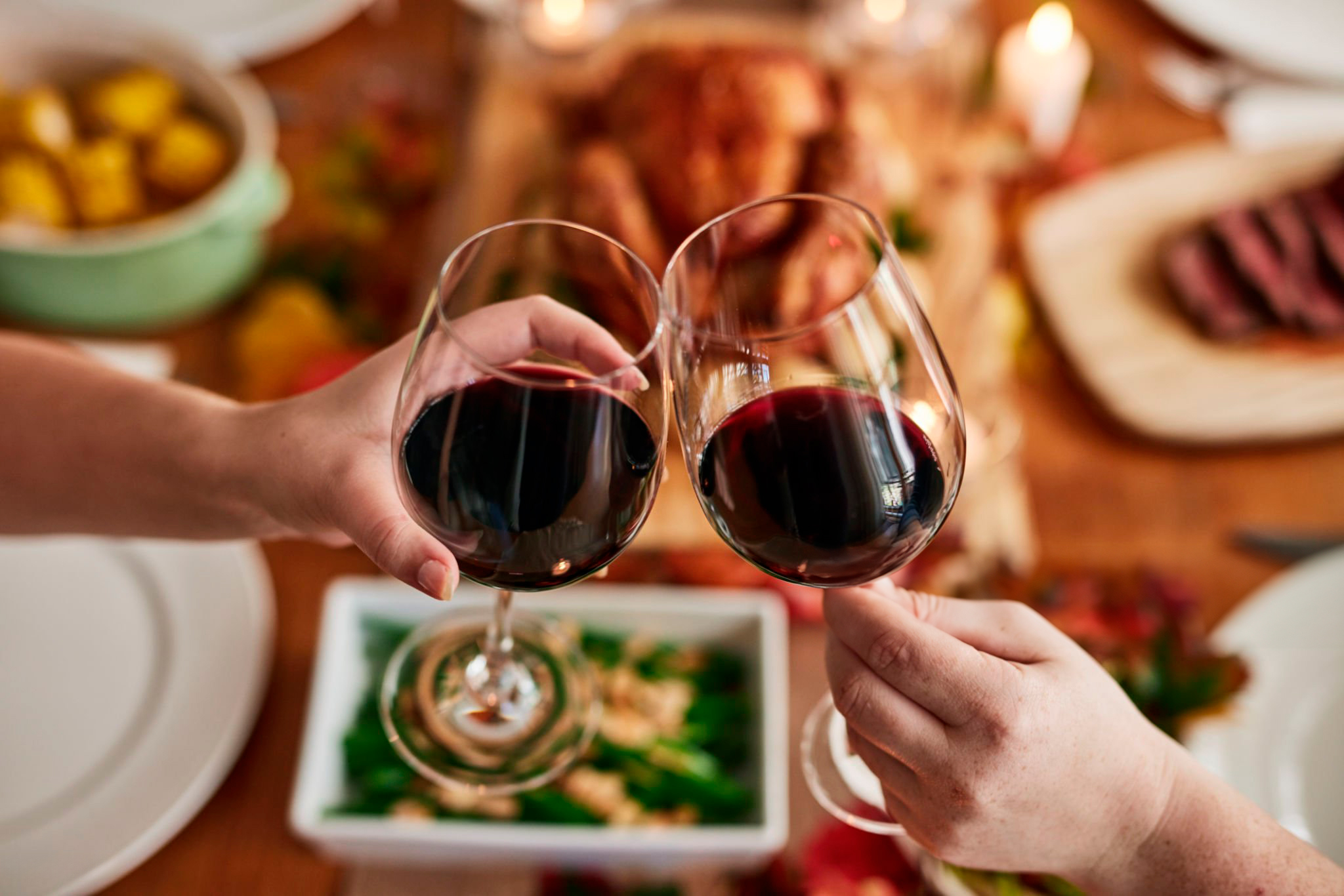 Pessoas brindando com taças de vinho na mão