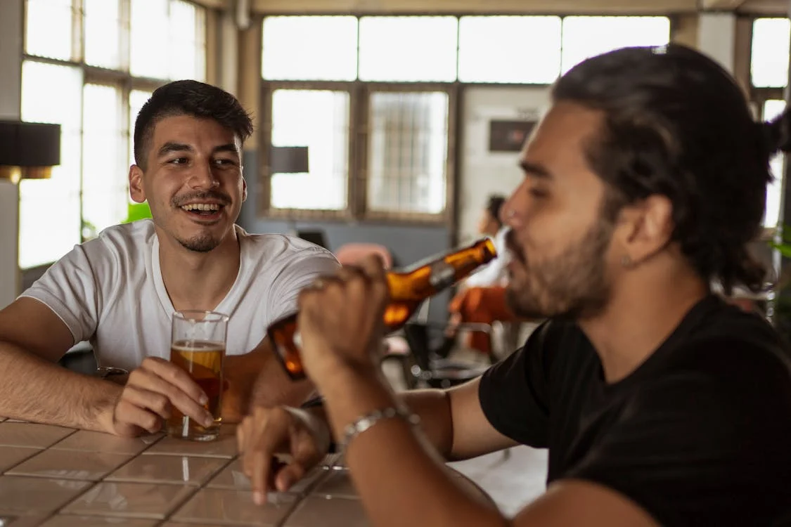 Dois amigos interagindo enquanto bebem